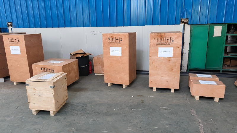 Locomotive parts packed in labeled wooden cases before loading.png